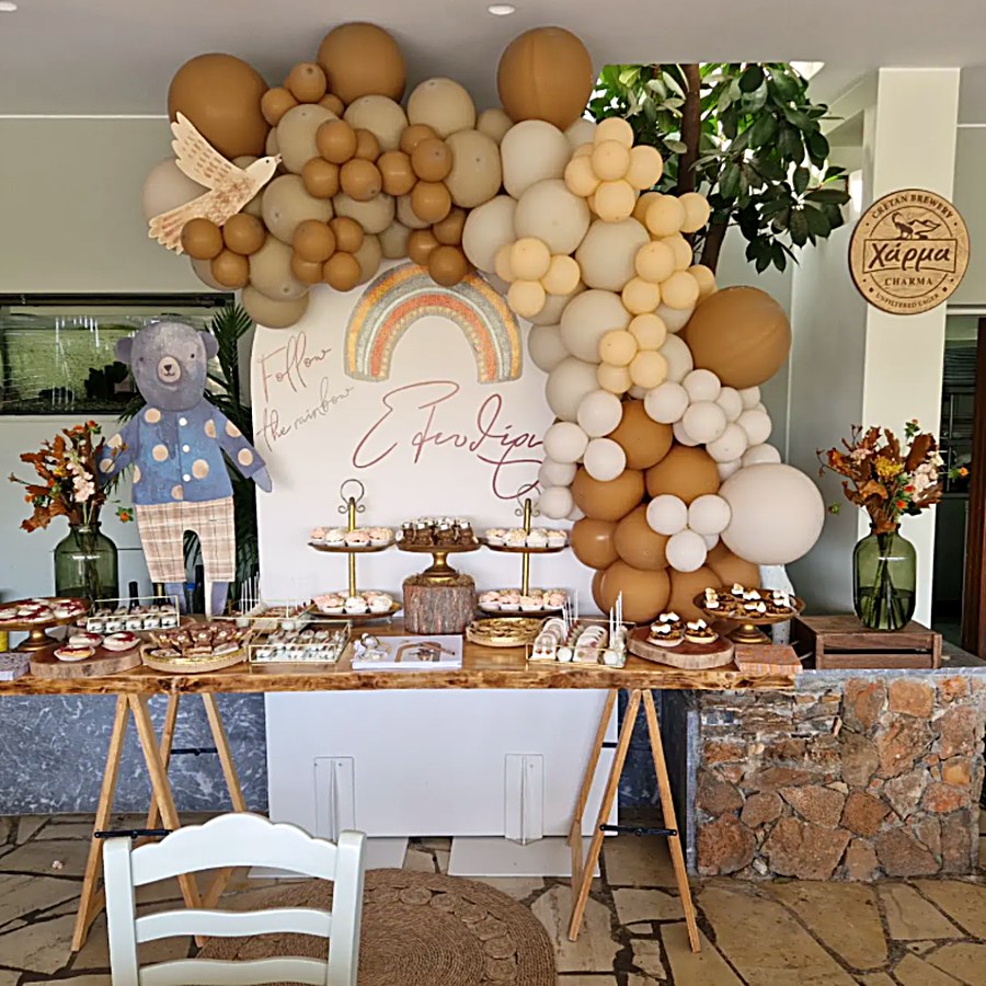 A celebration setup at Kri Kri with a soft balloon arch and dessert table