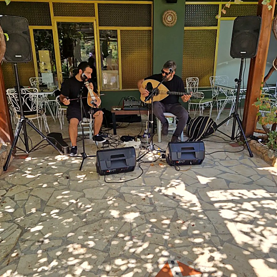 Two musicians playing Cretan lyra and lute on the Kri Kri terrace