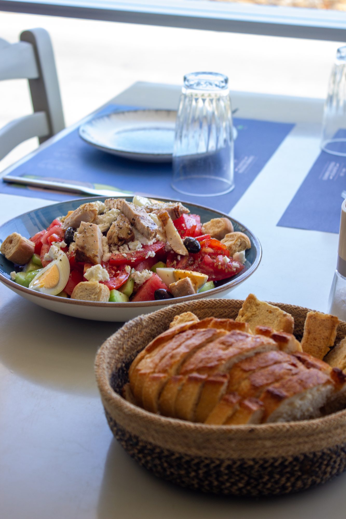 A salad and a basket of fresh bread on the table