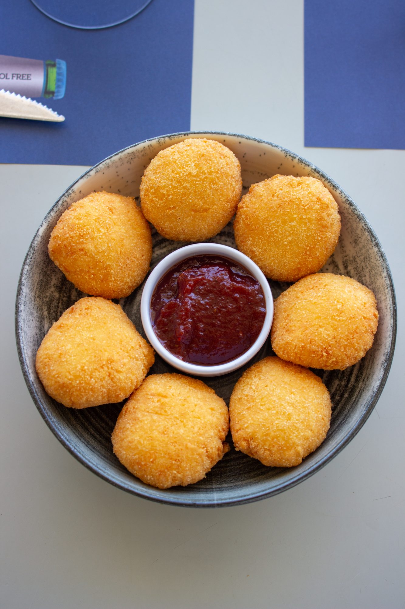 Golden fried cheese balls with a red dip