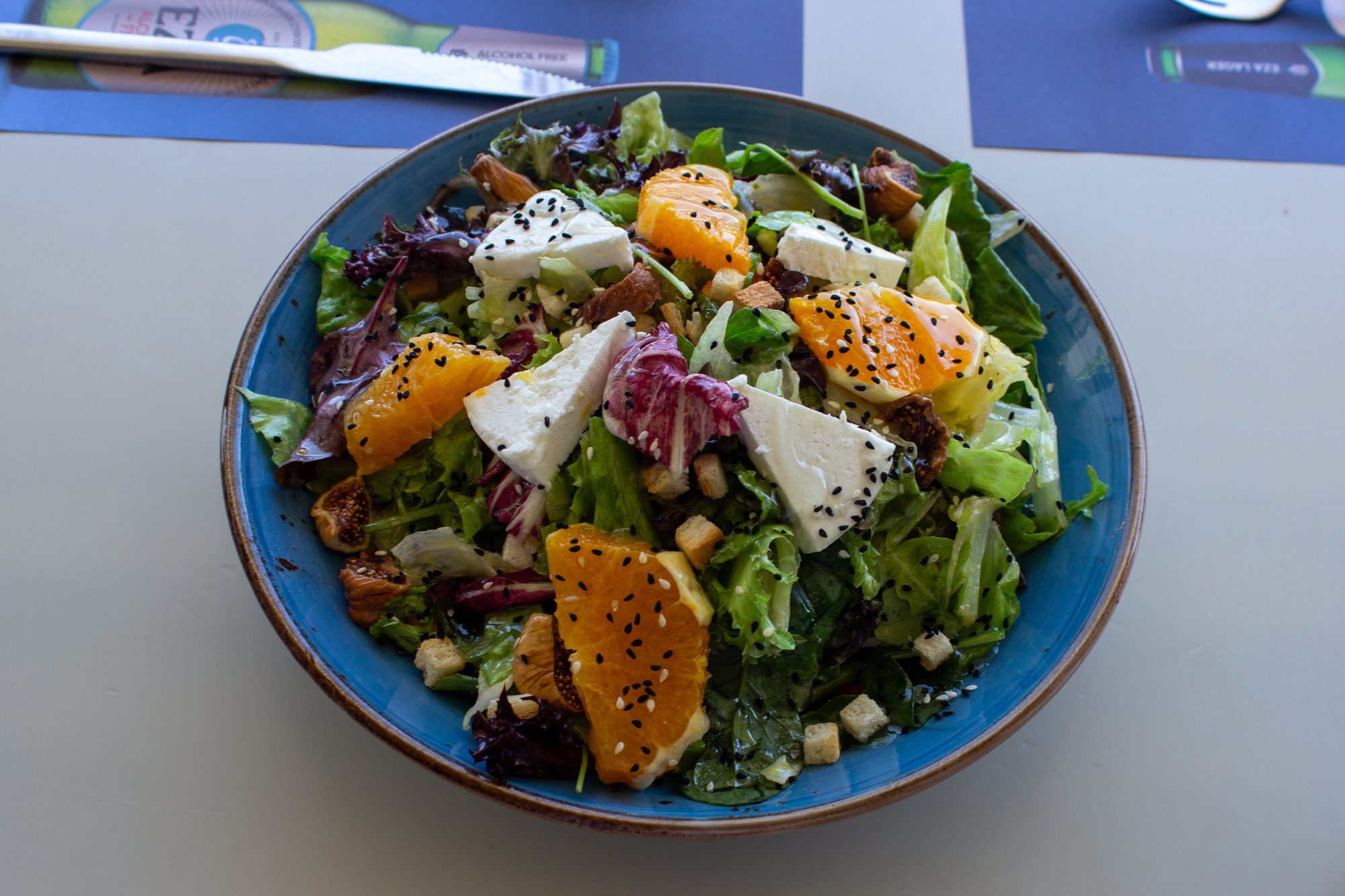 A green salad with orange, feta and black sesame