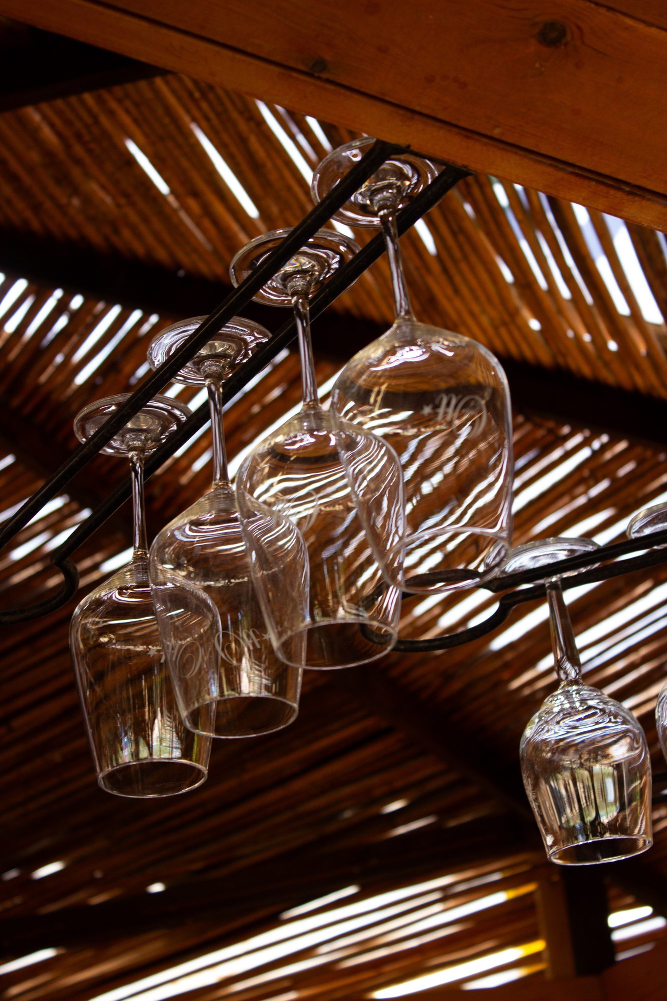 Wine glasses hanging under the reed ceiling
