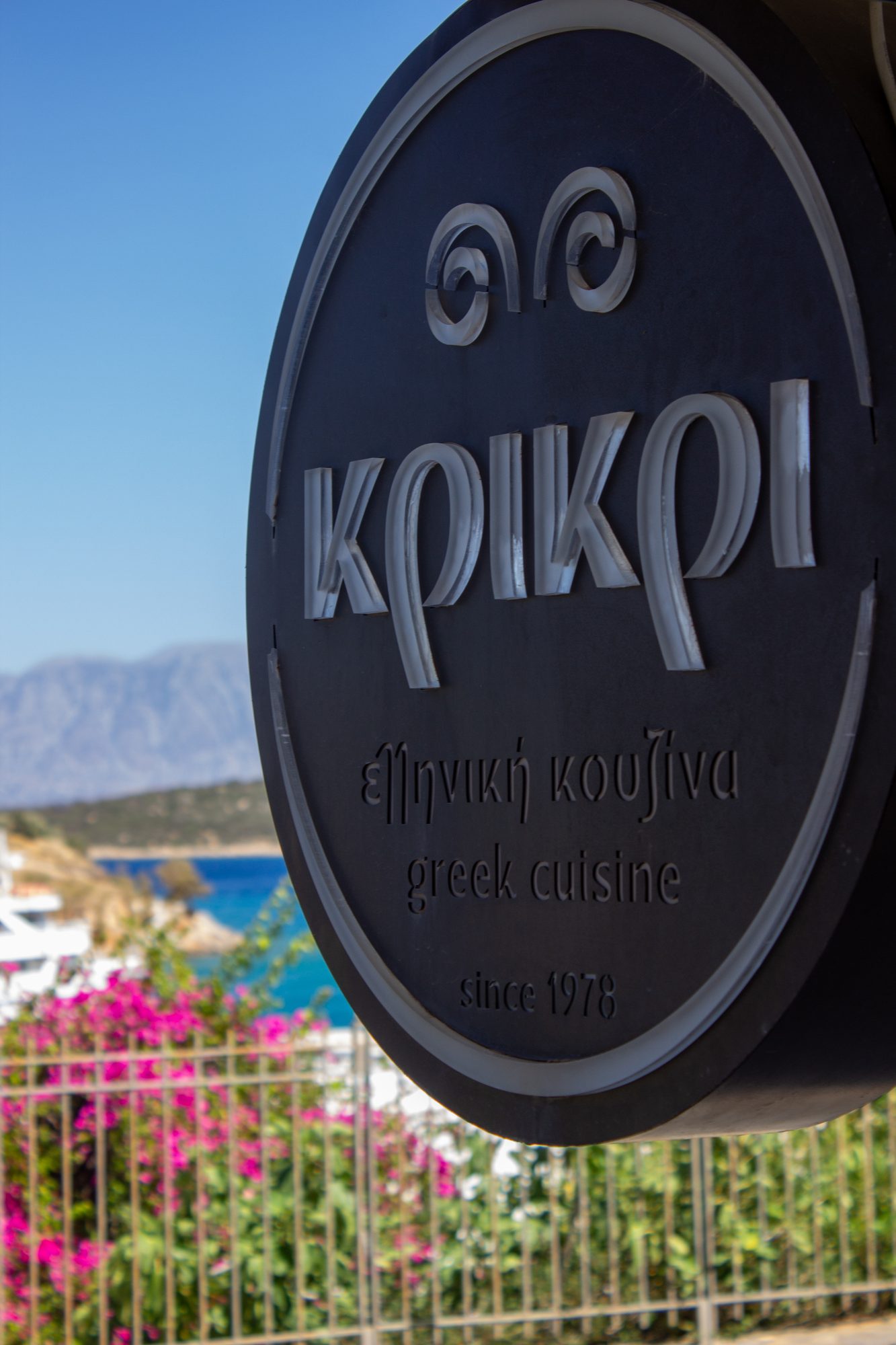 The Kri Kri sign framed by bougainvillea